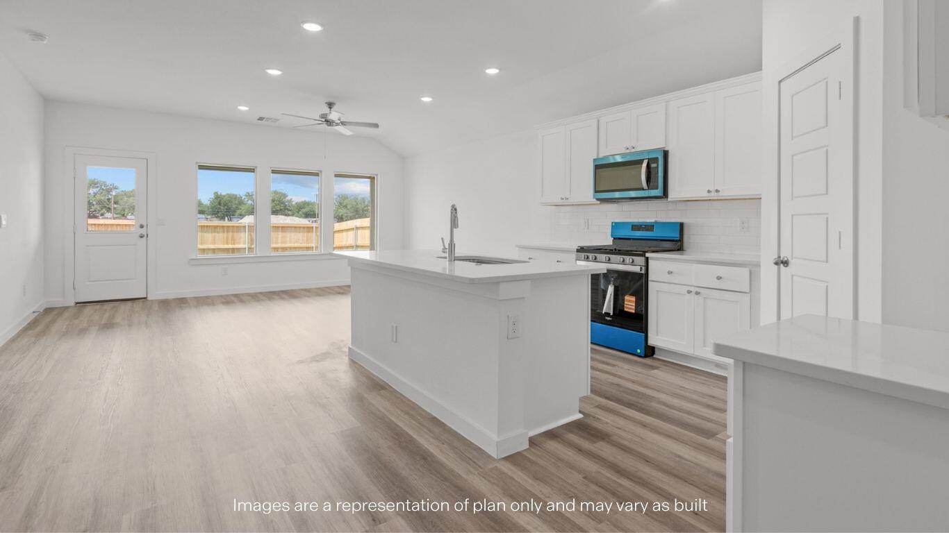 7411 9th Street Lubbock, TX 79416 - Photo 6 of 20 a kitchen with stainless steel appliances a stove top oven a sink a refrigerator white cabinets and wooden floor