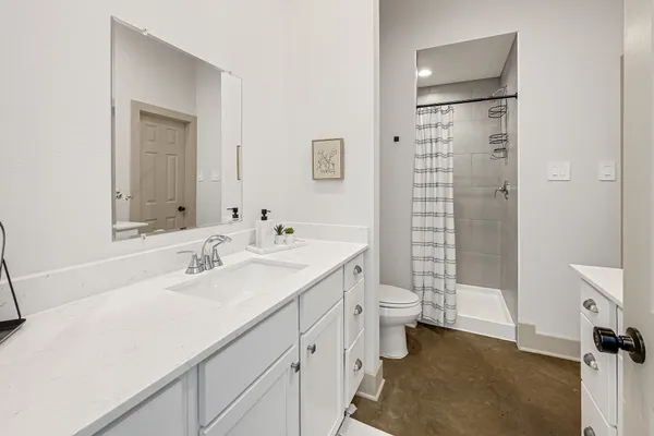 a bathroom with a double vanity sink toilet and shower