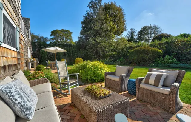 a view of patio with couches table and chairs and potted plants