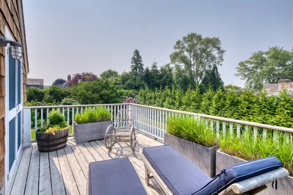 a view of a deck with two chairs next to a yard