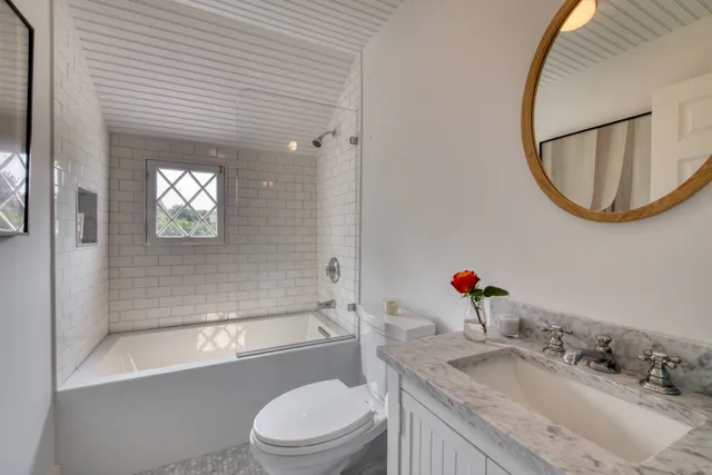 a bathroom with a granite countertop sink a toilet and shower