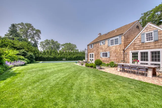 a view of a house with a yard and sitting area