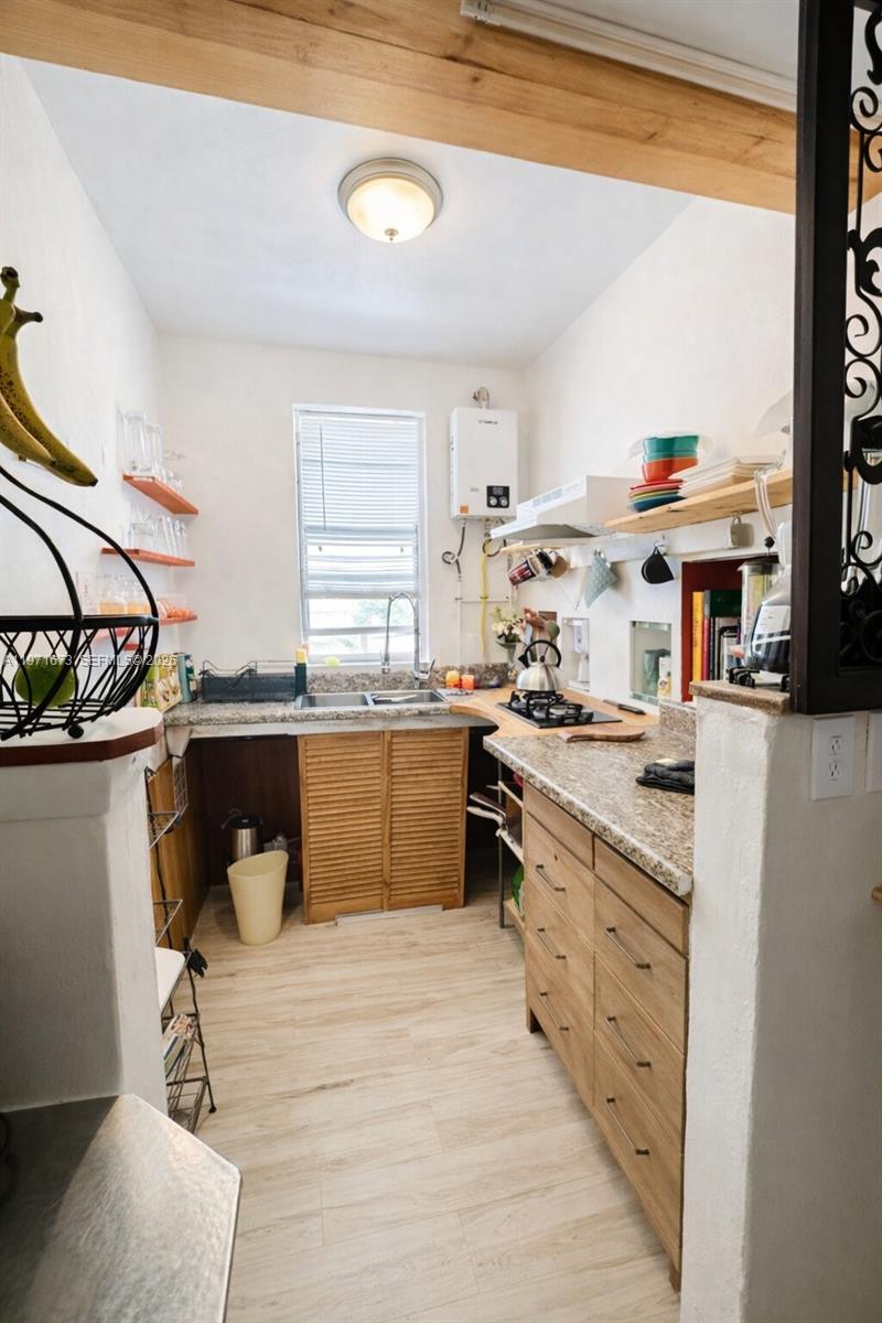 428 Southwest 9th Street, Unit 15 Miami, FL 33130 - Photo 5 of 13 a kitchen with stainless steel appliances kitchen island granite countertop a stove a sink and a refrigerator