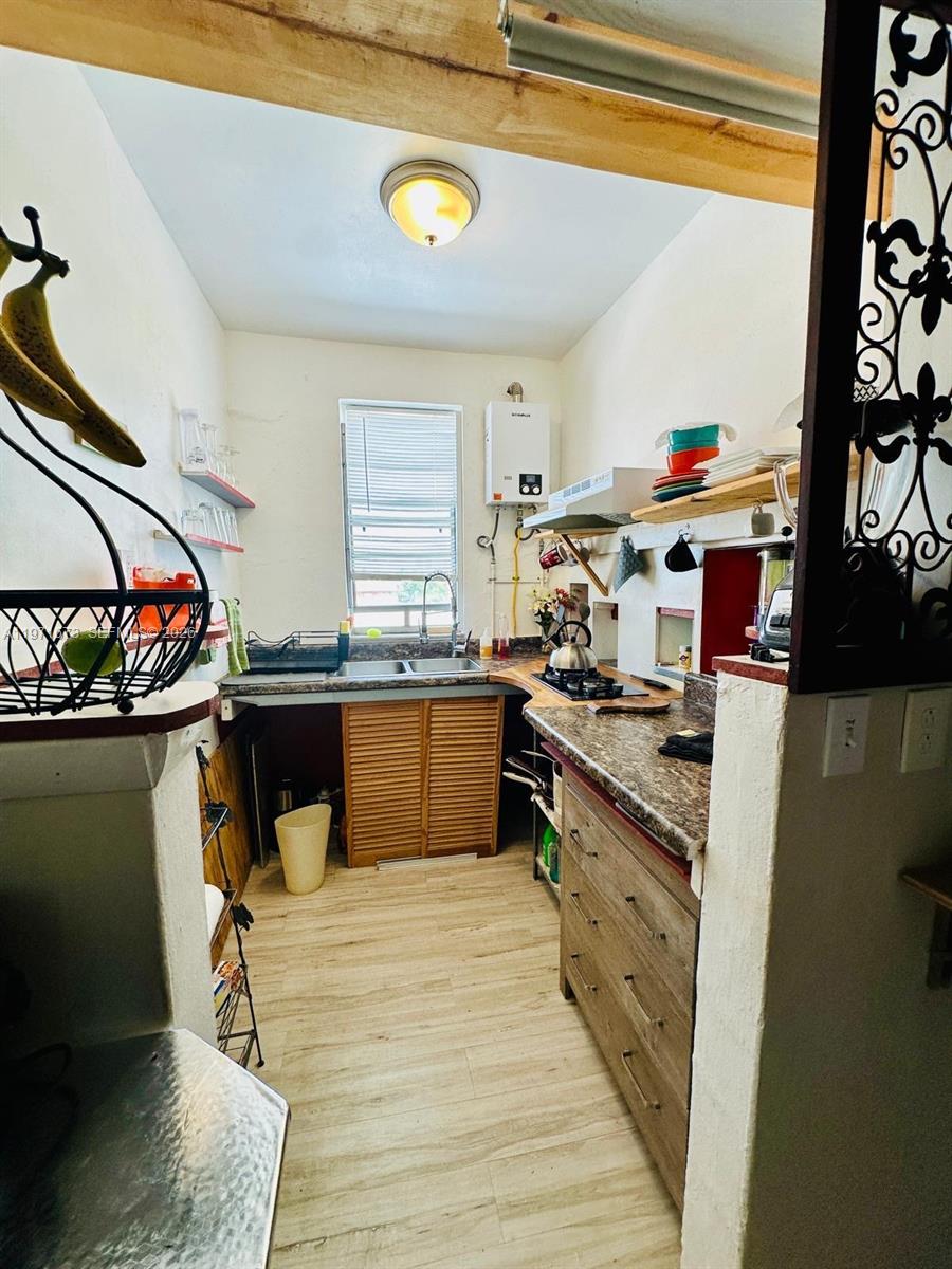 428 Southwest 9th Street, Unit 15 Miami, FL 33130 - Photo 5 of 13 a kitchen with stainless steel appliances granite countertop a stove a sink and a microwave