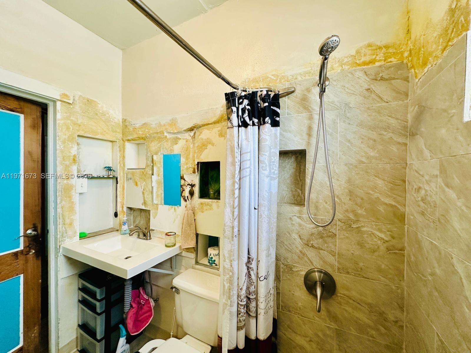 428 Southwest 9th Street, Unit 15 Miami, FL 33130 - Photo 8 of 13 a bathroom with a sink mirror toilet and shower