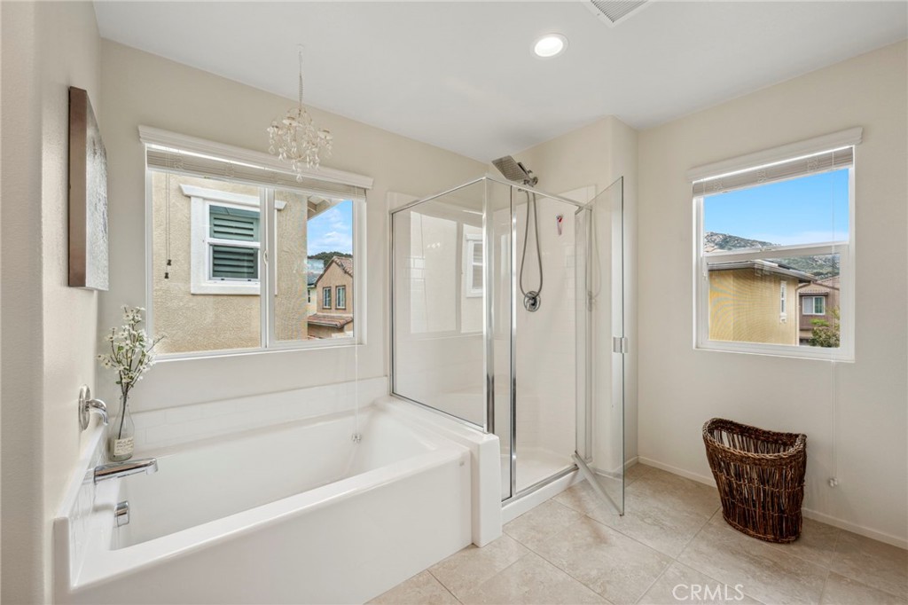 205 Spotted Saddle Way Fallbrook, CA 92028 - Photo 30 of 63 a bathroom with a bathtub a window and a shower
