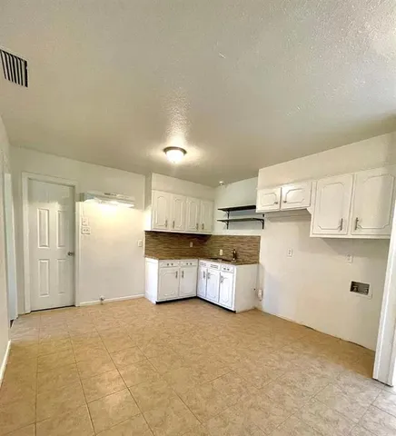 a view of a kitchen with a sink and dishwasher cabinets