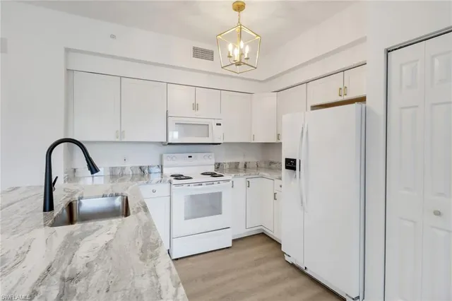 a kitchen with stainless steel appliances a refrigerator sink and white cabinets