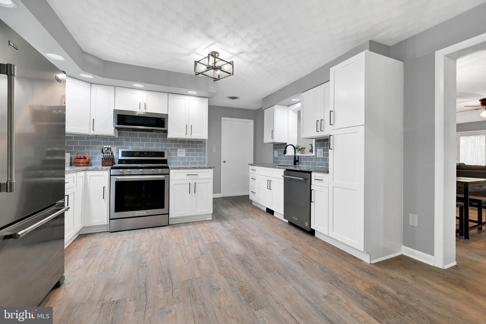 2340 Redwood Road York, PA 17408 - Photo 14 of 68 a kitchen with stainless steel appliances a stove top oven a sink dishwasher a refrigerator white cabinets and wooden floor
