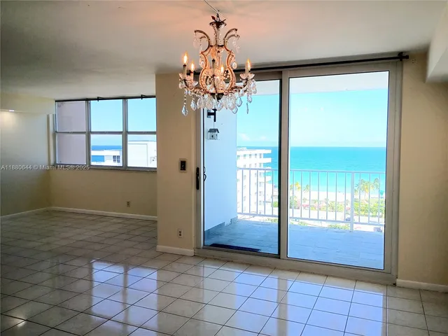 an empty room with windows and chandelier