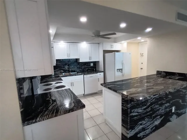 a kitchen with a stove and white cabinets