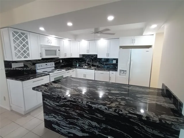 a large kitchen with stainless steel appliances a large counter top and stove
