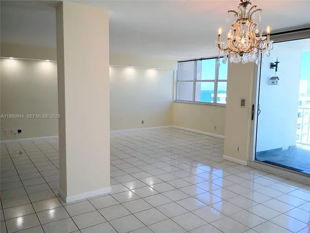an empty room with windows and chandelier