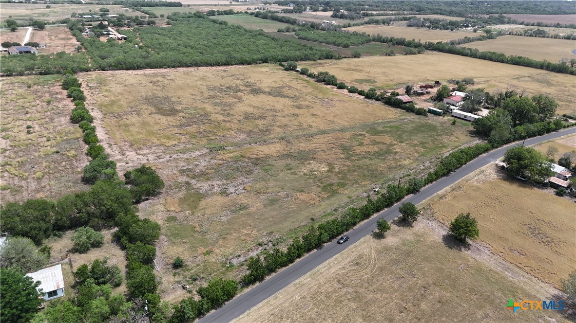 an aerial view of a house with a yard and mountain view in back