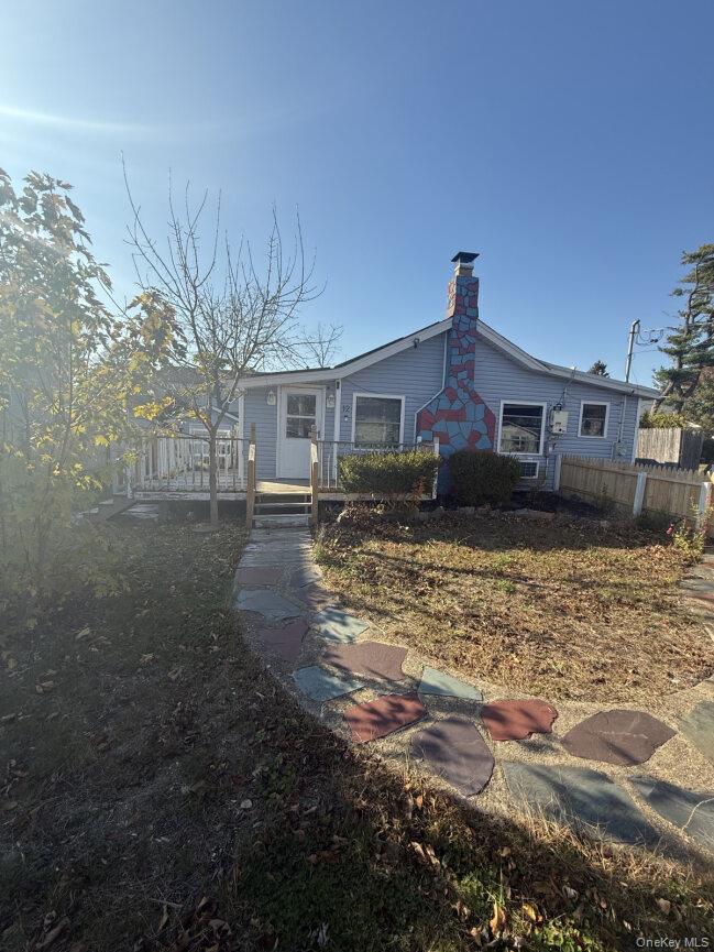 Undisclosed Address West Babylon, NY 11704 - Photo 1 of 8 Rear view of house featuring a chimney and a deck