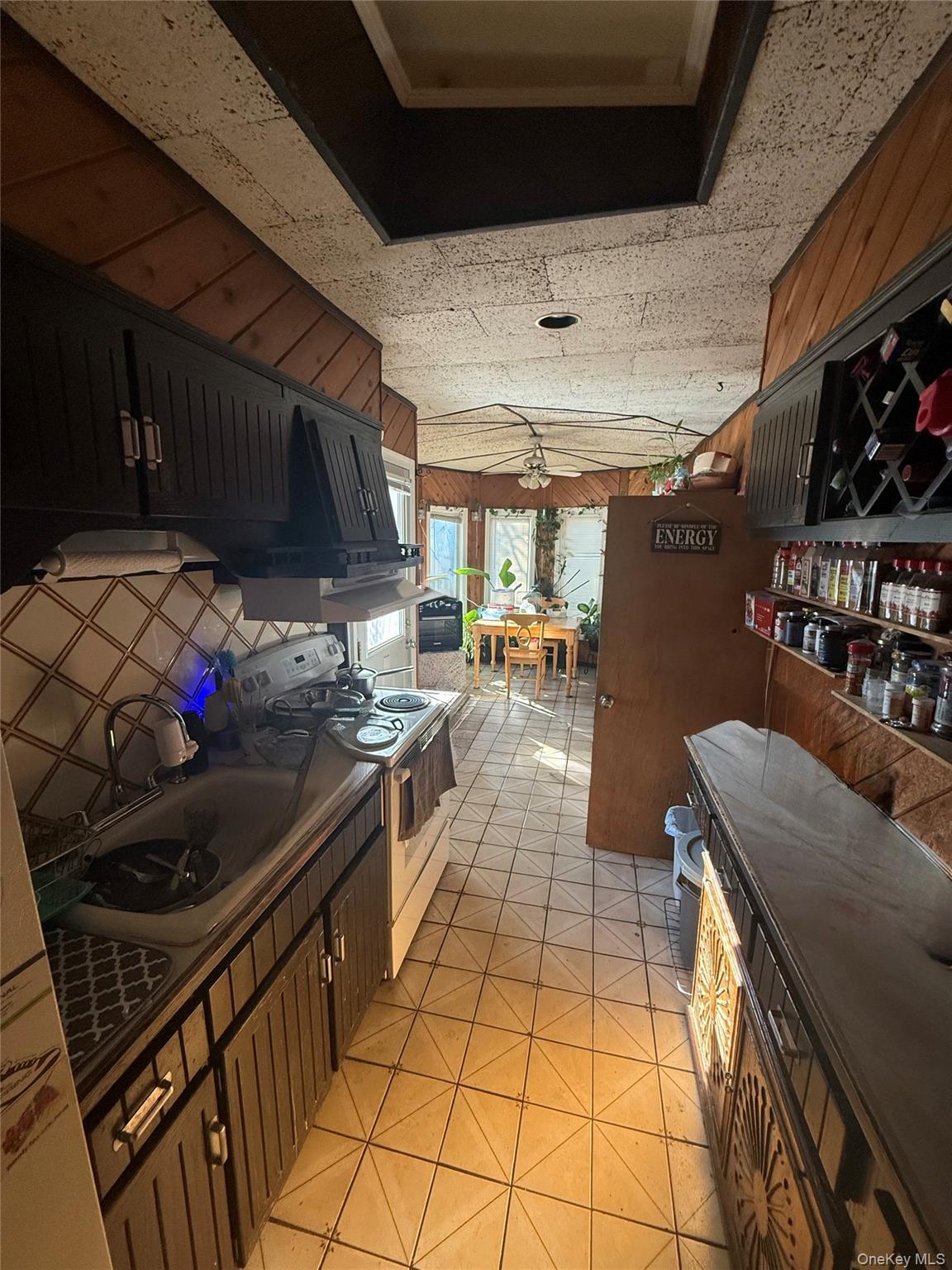 Undisclosed Address West Babylon, NY 11704 - Photo 4 of 8 Kitchen with wood walls, white stove, and dark countertops