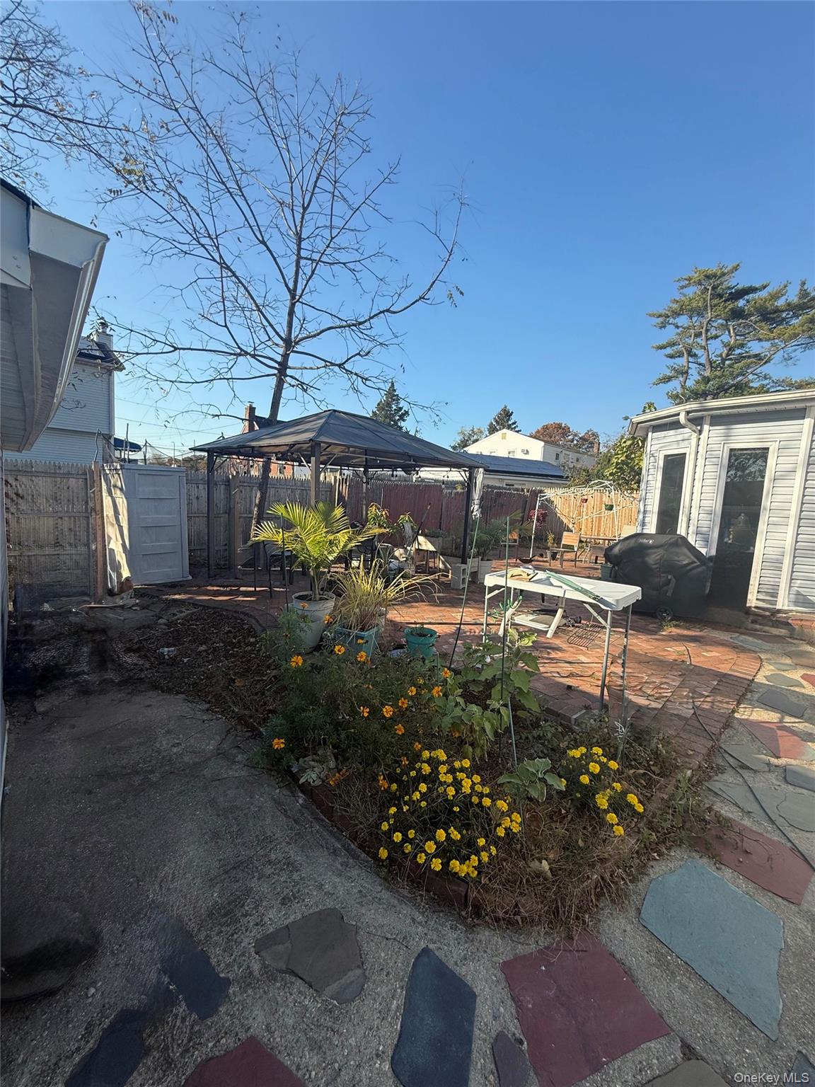 Undisclosed Address West Babylon, NY 11704 - Photo 7 of 8 Fenced backyard featuring a patio area and a gazebo