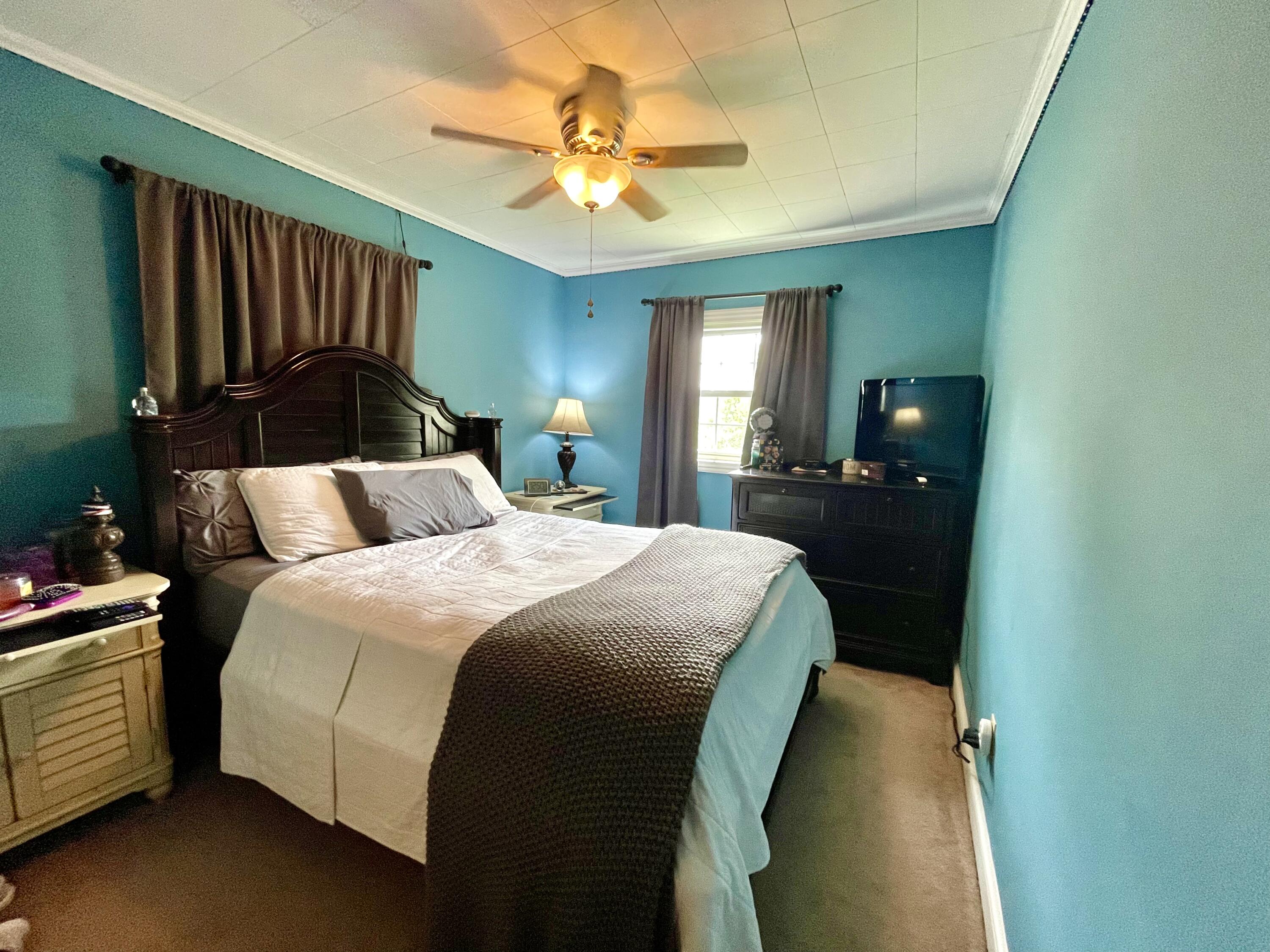 171 Oak Forest Road Bassett, VA 24055 - Photo 7 of 13 a spacious bedroom with a bed and a chandelier