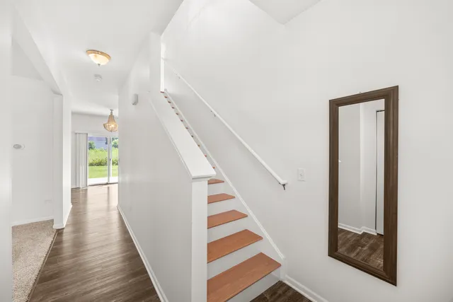 a view of a hallway with wooden floor and staircase