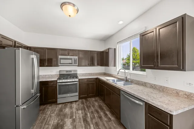 a kitchen with stainless steel appliances granite countertop a sink stove and refrigerator