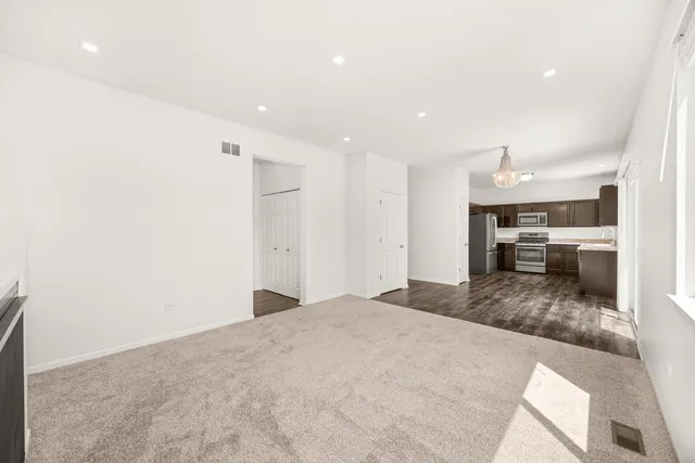 a large white kitchen with kitchen island a sink stainless steel appliances and cabinets