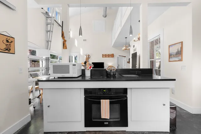 a bedroom with a bed a desk and chair with wooden floor