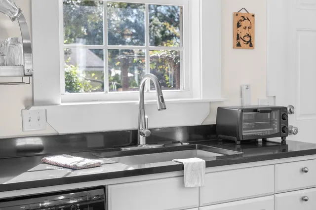 a spacious bedroom with a bed and a large window with wooden floor