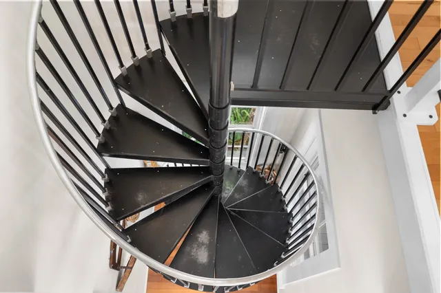 a view of a house with a small yard and wooden deck