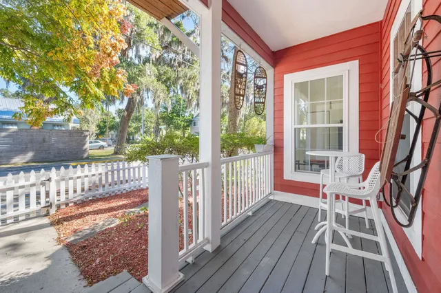 a view of a brick house with a small yard and large trees