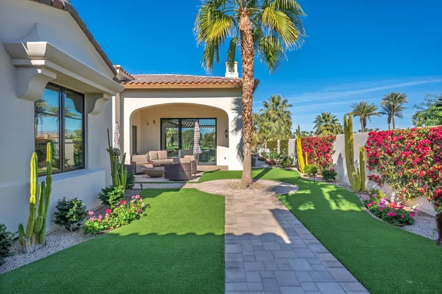 a living room with furniture a chandelier and a large window