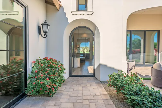 a living room with furniture a floor to ceiling window and a chandelier