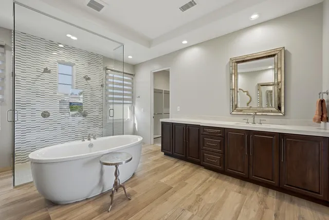 a bathroom with a sink a toilet a mirror and shower