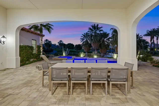 a view of a house with big yard and potted plants