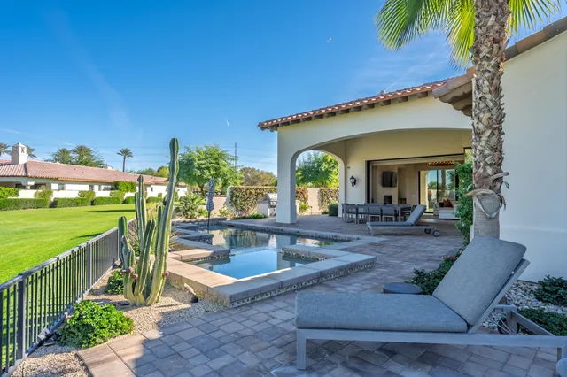 a view of a lake with couches and table and chairs under an umbrella