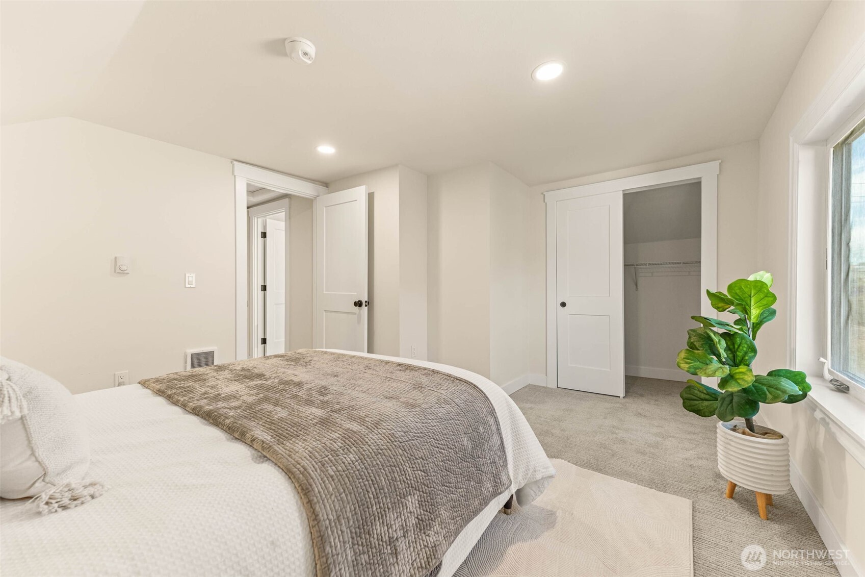 1520 31st Avenue Seattle, WA 98122 - Photo 15 of 27 a spacious bedroom with a bed and a potted plant