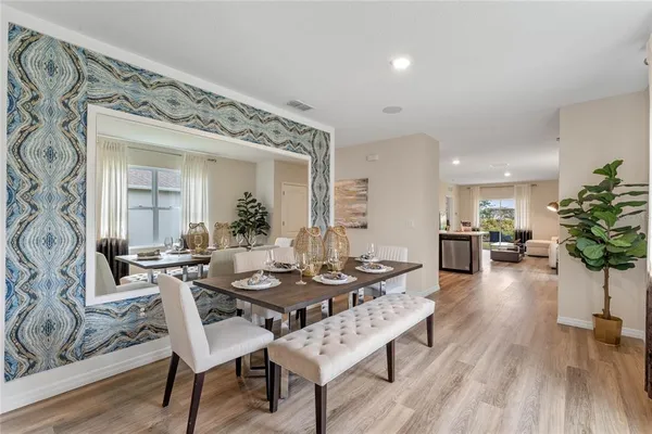 a dining room with furniture potted plants and wooden floor