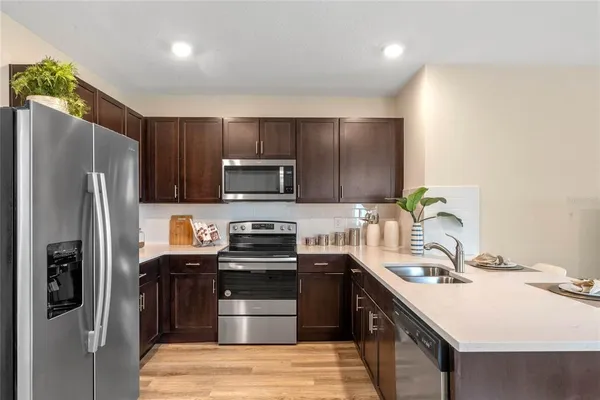 a kitchen with stainless steel appliances a sink stove refrigerator and cabinets