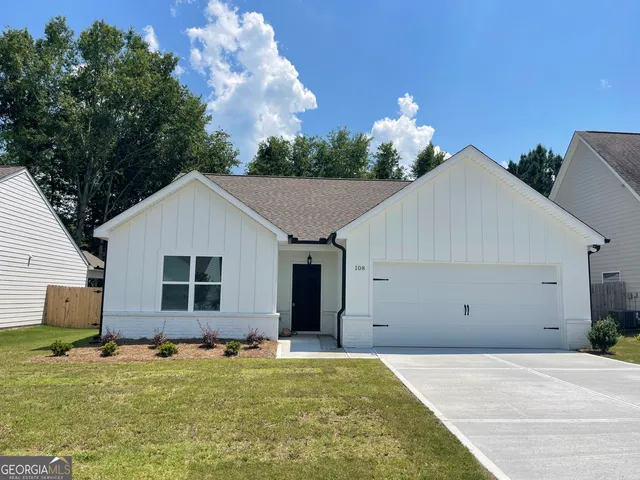 a backyard of a house with plants and outdoor seating