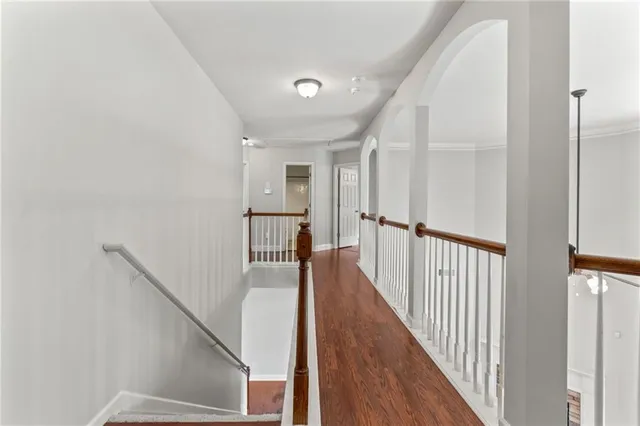 a view of a hallway with wooden floor and stairs