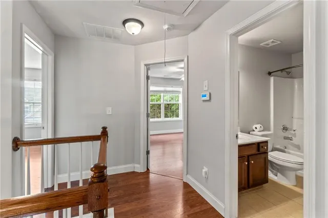 an empty room with wooden floor and window