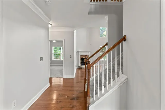 a view of a hallway with wooden floor and staircase