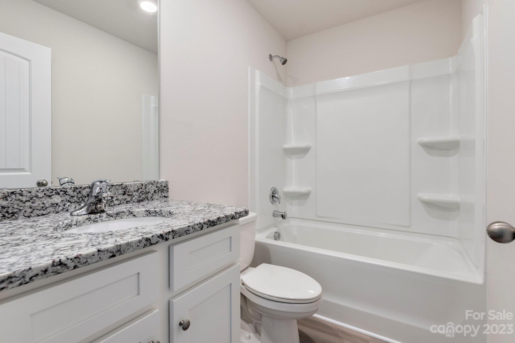 1145 Nia Road Charlotte, NC 28215 - Photo 17 of 17 a bathroom with a granite countertop sink a toilet and bathtub