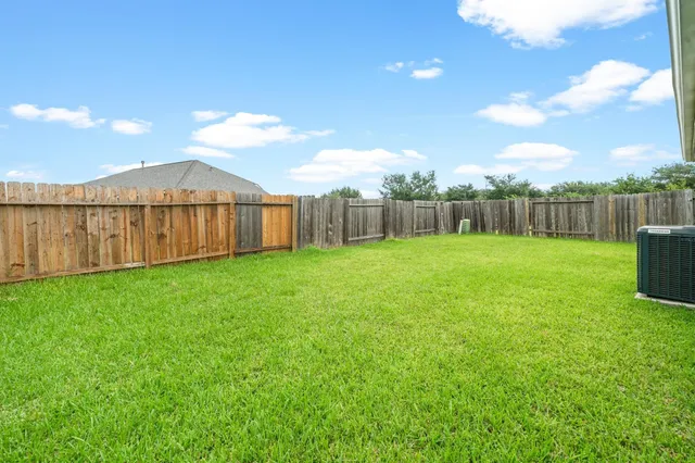 a view of a backyard with a garden and wooden fence