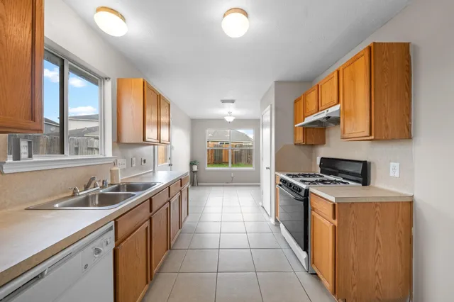 a kitchen with a sink a stove and cabinets