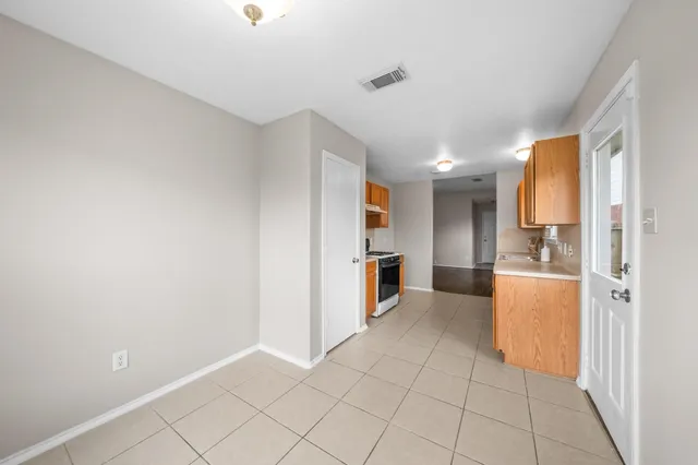 a view of a kitchen with refrigerator and white cabinets