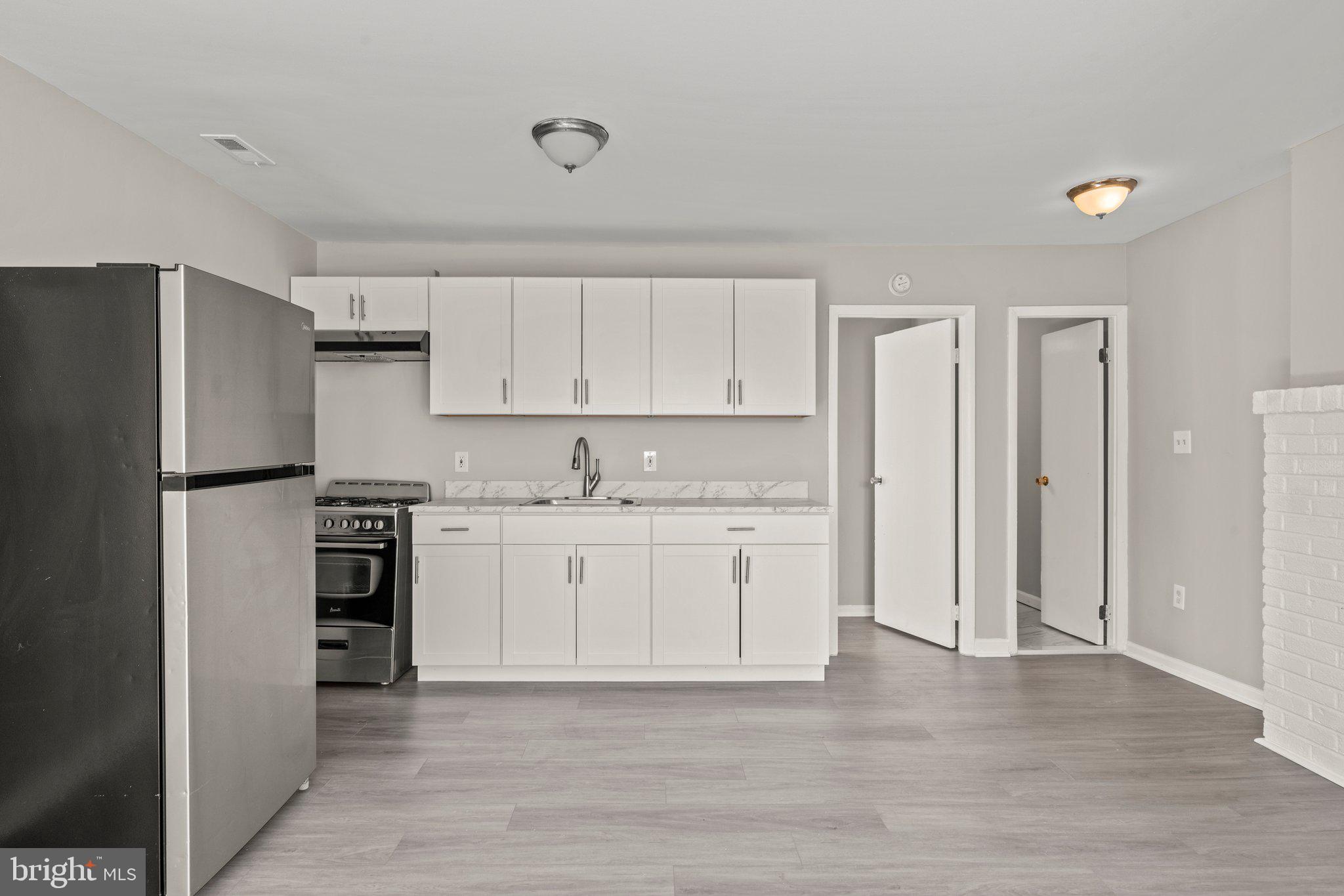 a kitchen with stainless steel appliances granite countertop a refrigerator and a stove top oven