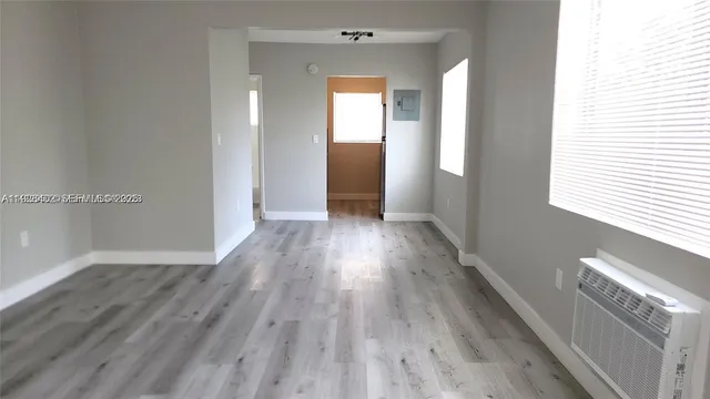 a view of a hallway with wooden floor and a window