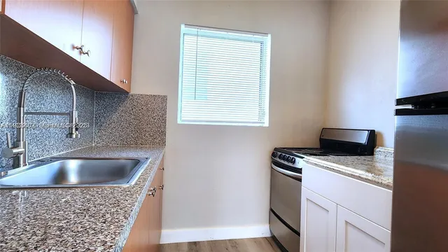 a kitchen with a sink a stove and a microwave