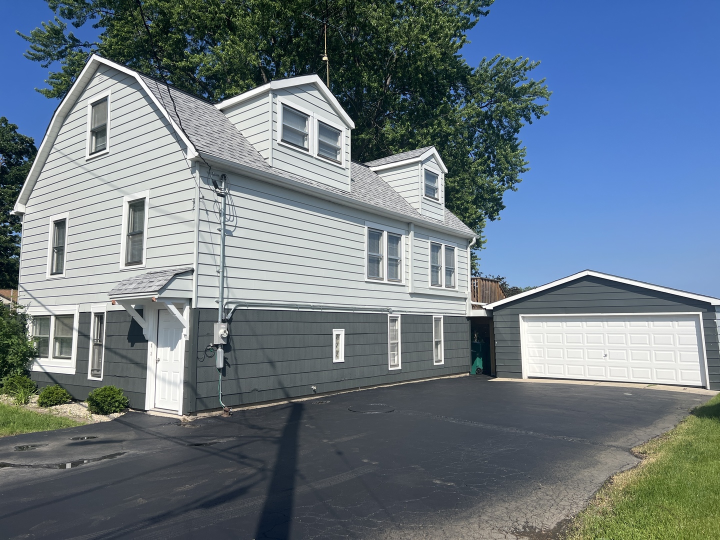 163 Eagle Point Road, Unit 1 Fox Lake, IL 60020 - Photo 1 of 23 a view of a white house with a yard and garage