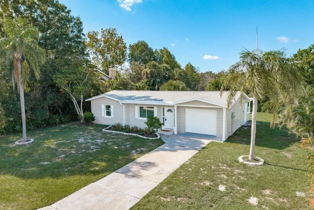 a view of a house with backyard and a tree